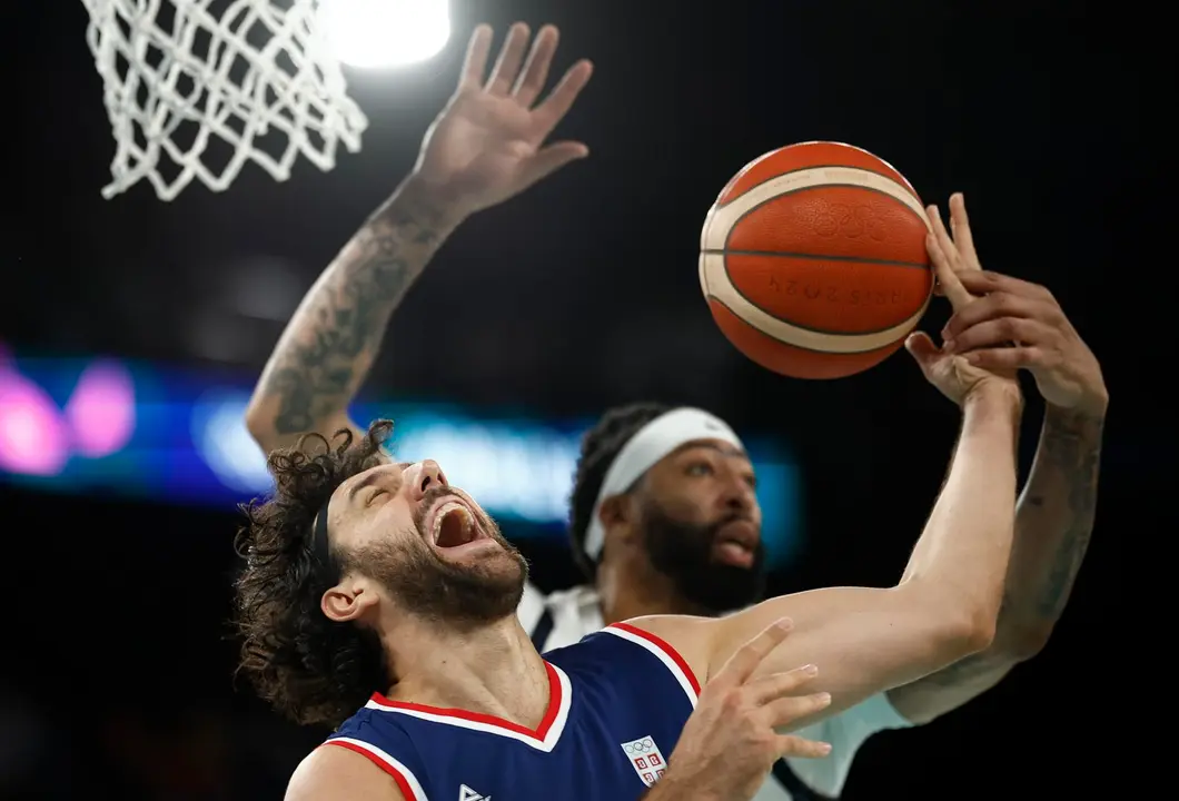 Paris, 08/08/2024.- (L-R) El serbio Vasilije Micic y el estadounidense Anthony Davis pelean por un bal&oacute;n en la semifinal de los Juegos de Par&iacute;s 2024 disputada hoy en Paris Bercy y que acab&oacute; con triunfo norteamericano EFE/EPA/YOAN VALAT