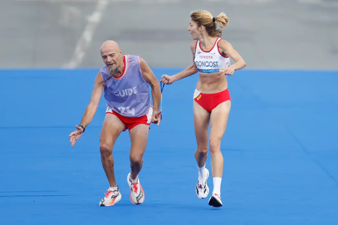 La atleta espa&ntilde;ola Elena Congost, medalla de bronce en la final de la marat&oacute;n T12 femenino, ayuda a su gu&iacute;a, que llega exhausto a la l&iacute;nea de meta, en los Juegos Paral&iacute;mpicos de Par&iacute;s 2024. Congost fue descalificada por soltar la cuerda que la un&iacute;a a su gu&iacute;a, Mia Carol Bruguera, que lleg&oacute; a la recta final con calambres y sufriendo en los &uacute;ltimos metros. EFE/ Javier Etxezarreta